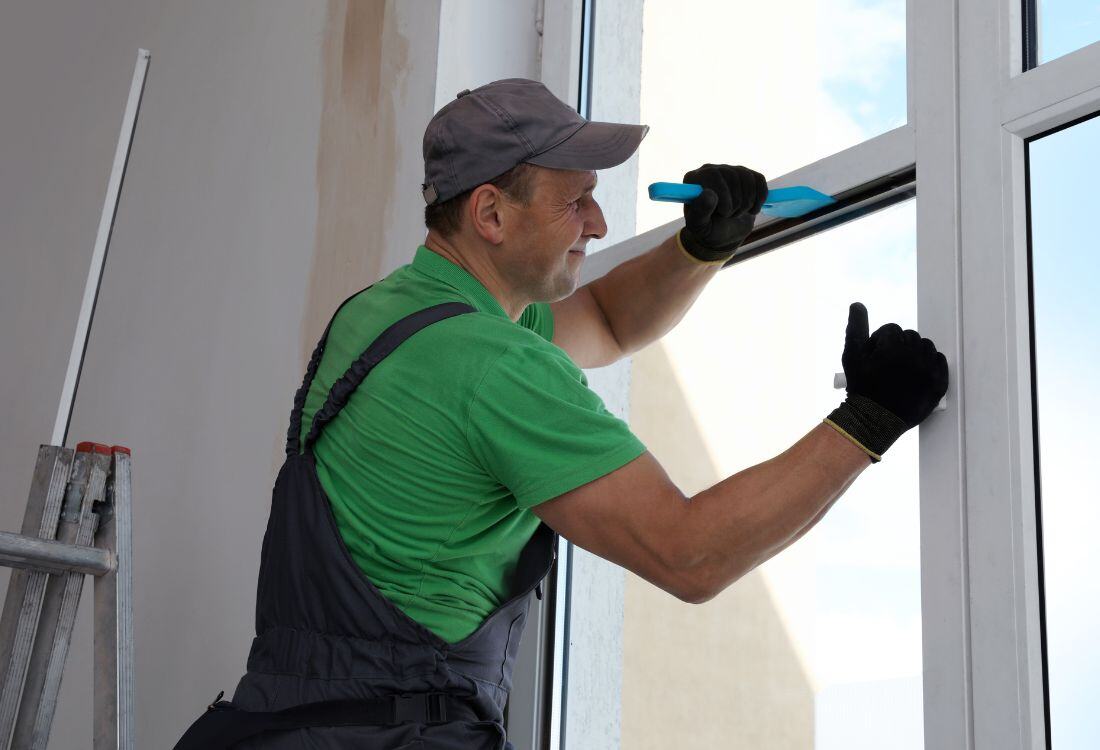 A worker installing a double glazed window from potentially a national double glazing company or a local independent company. 