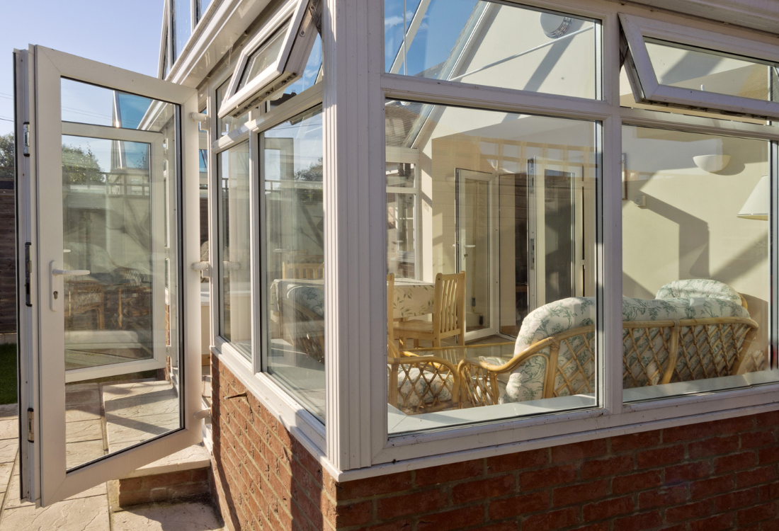 A large conservatory which is letting in lots of natural light into a home.  