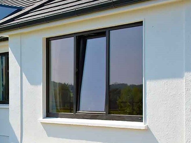 A black tilt and turn window on a modern white house.